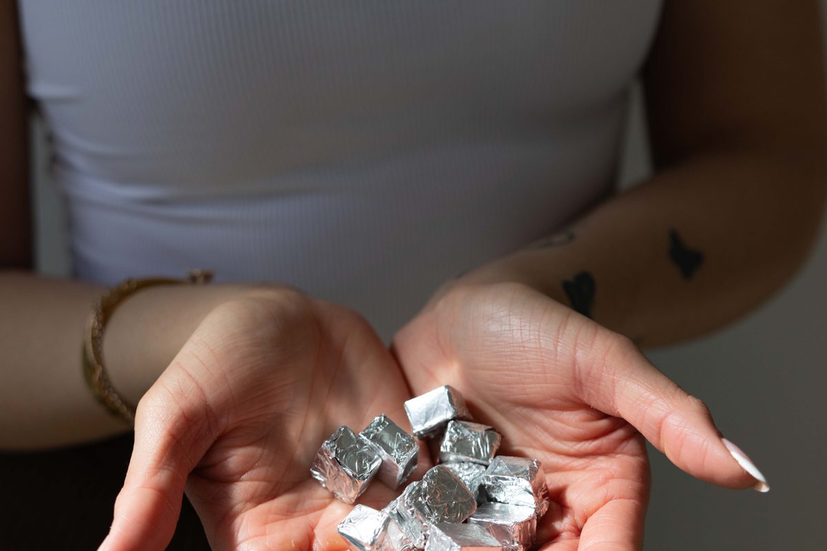 Two open hands cupping foil wrapped Bliss Bites.