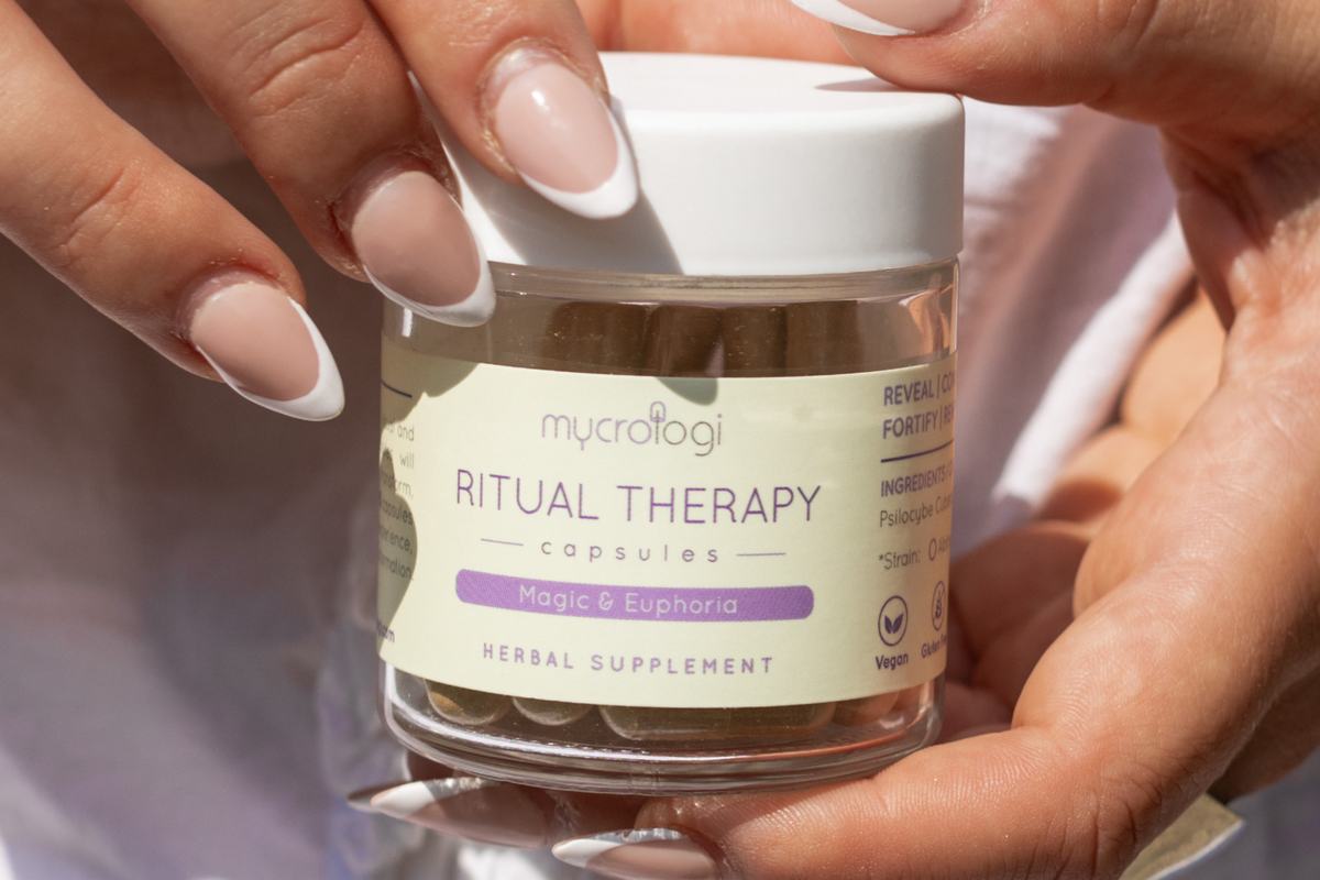 Two hands holding a jar of Mycrologi Ritual Therapy capsules